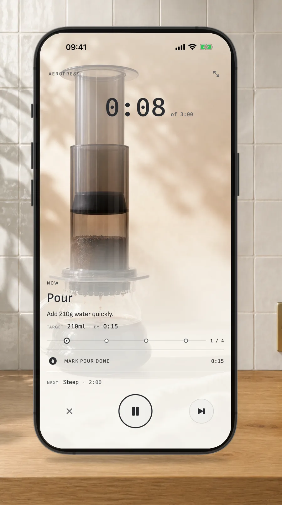 A straight iPhone on a stainless kitchen counter showing a guided Hario V60 brew timer.